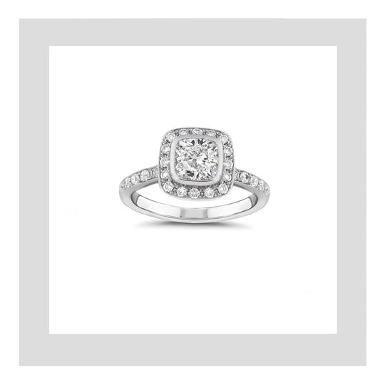 Platinum engagement ring featuring a cushion cut diamond and complimented with diamonds set around the centre stone and the ring band.