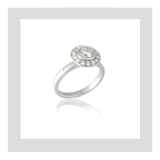Platinum engagement ring featuring a round diamond centre stone with a diamond halo for a contemporary and minimal design.