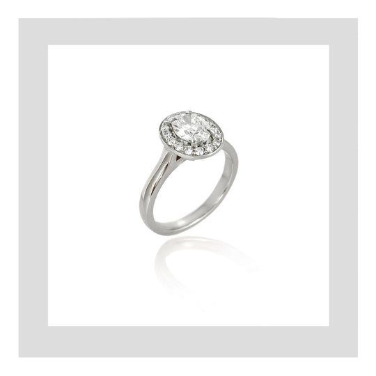 Platinum handmade engagement ring featuring a 0.60ct oval diamond and micor pavé set diamond halo.
